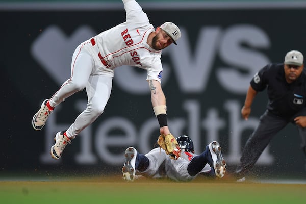 Boston Red Sox shortstop Trevor Story, top left, is unable to get his glove on Atlanta Braves' Eli White, bottom, as White steals second base in the fourth inning of a baseball game, Saturday, May 17, 2025, in Boston. (AP Photo/Steven Senne)