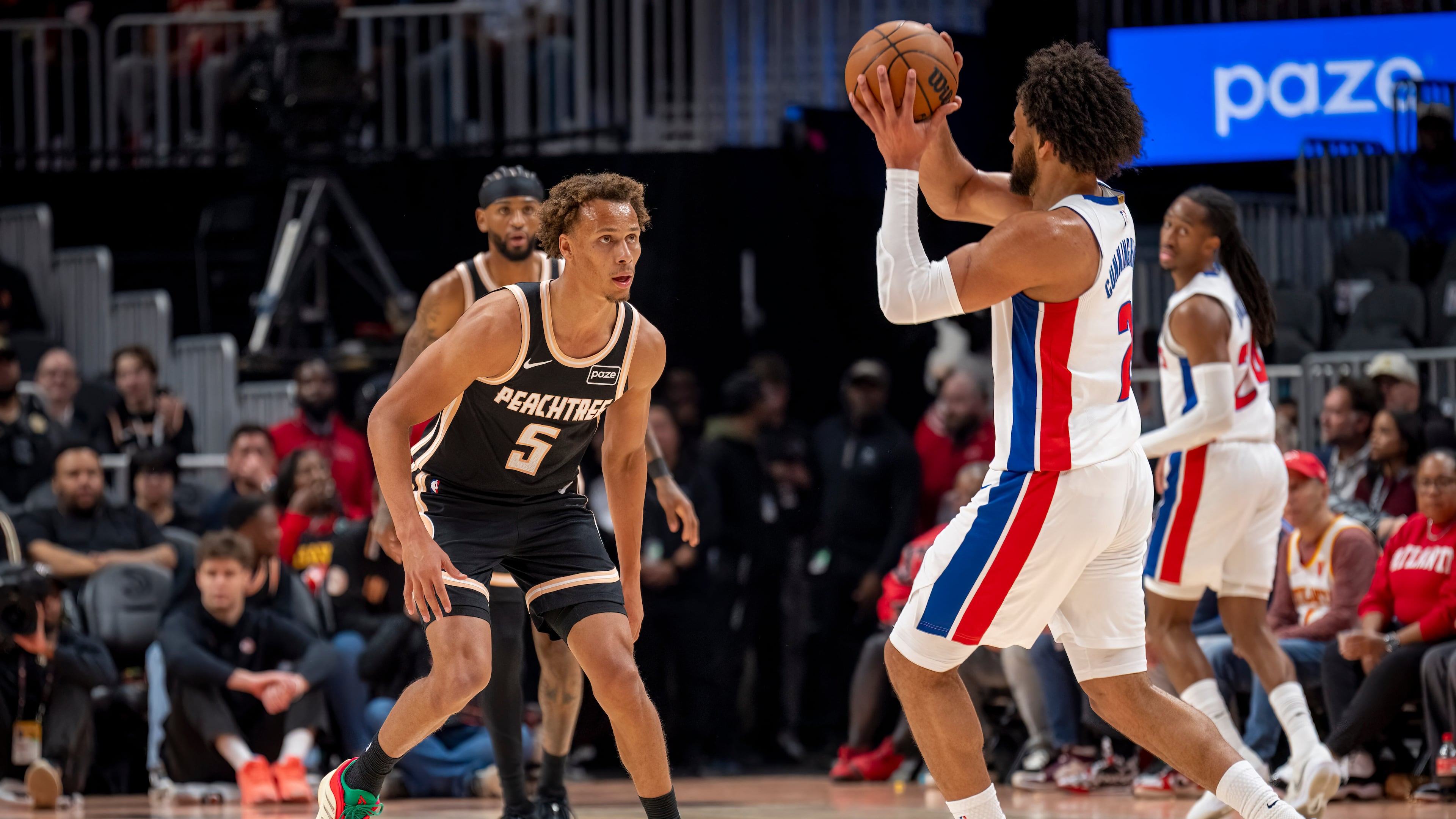 Atlanta Hawks guard Dyson Daniels (5) defends the goal against Detroit Pistons guard Cade Cunningham during the first half of an NBA basketball game, Tuesday, Nov. 18, 2025, in Atlanta. (AP Photo/Erik Rank)