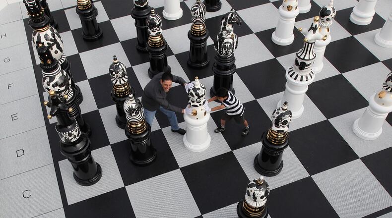 People move pieces on a giant Chess set in Trafalgar Square on September 18, 2009 in London, England. The Chess set which launches this years London Design festival, consists 32 two metre high ceramic pieces on a mosaic glass chess board that were designed and created by Spanish artist Jaime Hayon. (Photo by Dan Kitwood/Getty Images)