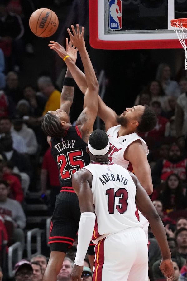 Miami Heat forward Kyle Anderson, right, blocks a shot by Chicago Bulls forward Dalen Terry during the first half of an NBA play-in tournament basketball game in Chicago, Wednesday, April 16, 2025. (AP Photo/Nam Y. Huh)