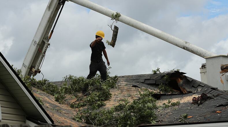090216 VALDOSTA: A member of a tree service company removes a tree from the roof of a damaged home during storm cleanup in the aftermath of Hurricane Hermine on Friday, Sept. 2, 2016, in Valdosta. Curtis Compton /ccompton@ajc.com