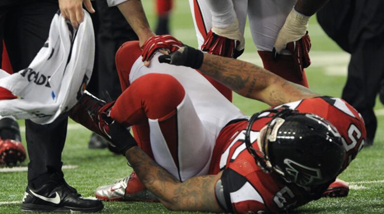 Falcons defensive end holds on to his left ankle after suffering an injury in the second half of Atlanta's 22-17 loss to the Buccaneers in the regular season finale at the Georgia Dome.