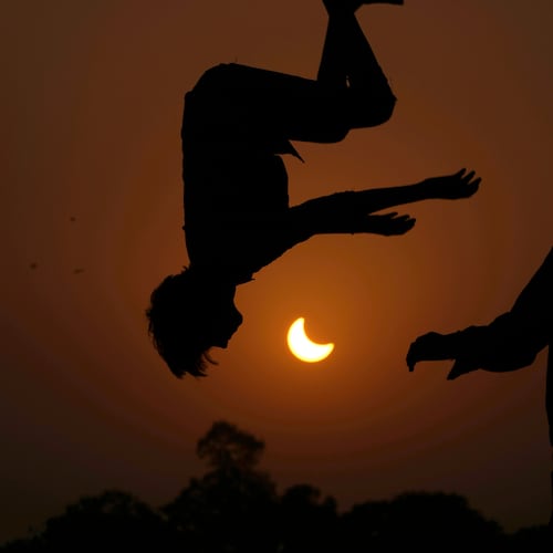 FILE - The partial solar eclipse is framed by youngsters jumping on a trampoline in the outskirts of Lahore, Pakistan, Oct. 25, 2022. (AP Photo/K.M. Chaudary, File)