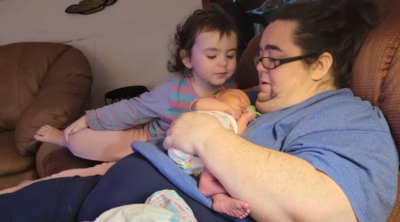 Amanda Jones holds her newborn daughter, Miranda, at their home in Macon in December 2022, and her toddler, Katie. Jones died in June 2023. Jones and similar women's deaths are reviewed by the state to determine if they were caused by pregnancy. (Contributed)