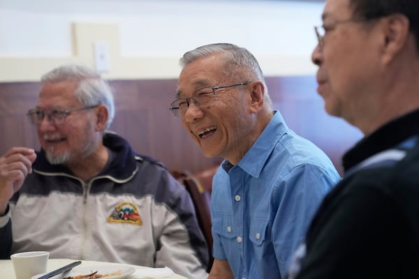 William Fong, middle, laughs while having lunch with classmates from his 1961 8th grade class at a restaurant in San Francisco, Wednesday, April 23, 2025. (AP Photo/Jeff Chiu)