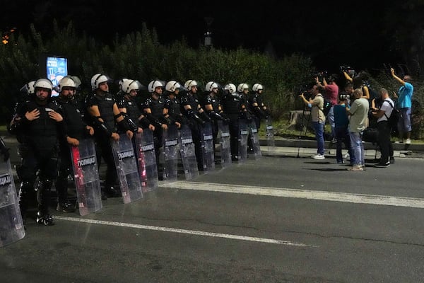 Riot police block a street to prevent clashes between anti-government protesters and government supporters at the end of a rally pressing for an early election after nearly eight months of almost daily anti-corruption demonstrations that have shaken the populist government of President Aleksandar Vucic, in Belgrade, Serbia, Saturday, June 28, 2025. (AP Photo/Darko Vojinovic)