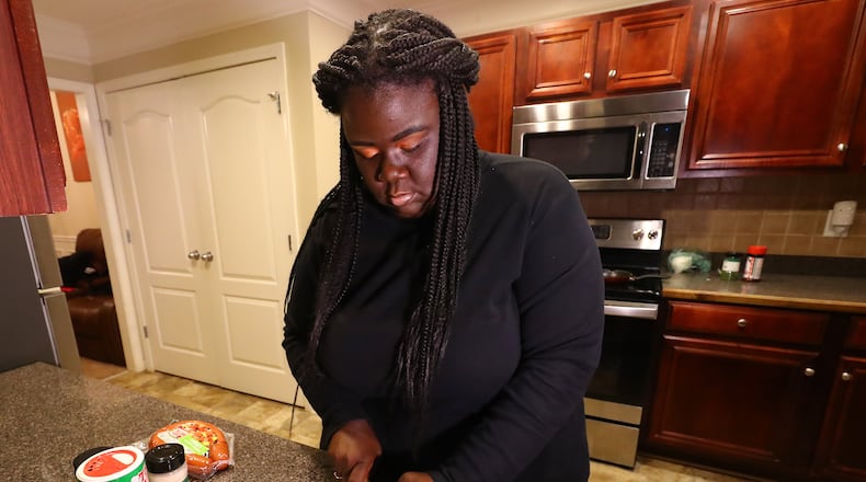 Porscha Schley, of Decatur, spent months wary of getting vaccinated before she consented to getting vaccinated after a trusted mentor answered her questions and her workplace instituted a mandate. She now advocates for others to get vaccinated, saying they can protect themselves and their families. Now vaccinated, on a recent evening she gathered with family for dinner at a relative's home in McDonough. (Curtis Compton / Curtis.Compton@ajc.com)