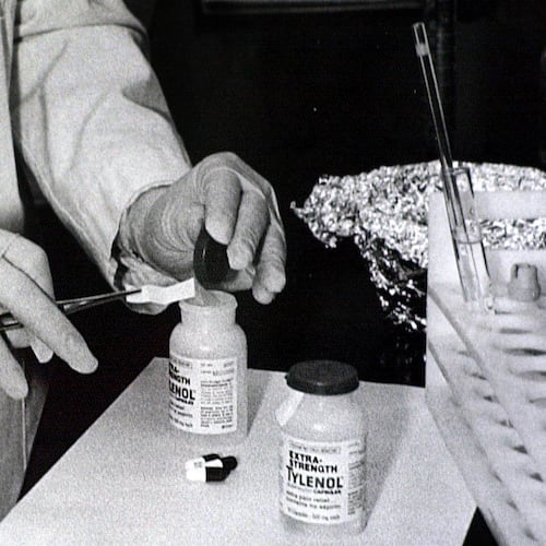 FILE - Bottles of Extra-Strength Tylenol are tested with a chemically treated paper that turns blue in the presence of cyanide at the Illinois Department of Health in Oct. 1982, in Chicago. (AP Photo/John Swart, File)