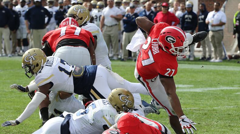 Georgia tailback Nick Chubb (27) goes over the top for a touchdown against Georgia Tech during the first quarter of an NCAA college football game on Saturday, Nov. 25, 2017, in Atlanta. (Curtis Compton/Atlanta Journal-Constitution via AP)