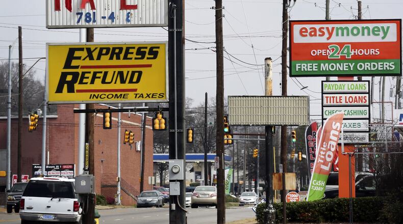 Signs advertise short-term loans stands in Birmingham, Alabama, in 2015. The federal Consumer Financial Protection Bureau has released sweeping new proposed rules that take aim at the payday lending industry, but consumer advocates say they could undermine Georgia’s ban on such high-cost loans. Bloomberg photo by Gary Tramontina.