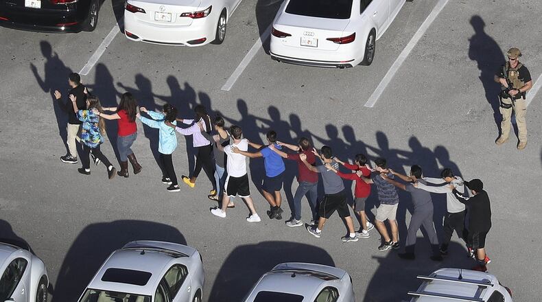 PARKLAND, FL - FEBRUARY 14: People are brought out of the Marjory Stoneman Douglas High School after a shooting at the school that reportedly killed and injured multiple people on February 14, 2018 in Parkland, Florida. Numerous law enforcement officials continue to investigate the scene. (Photo by Joe Raedle/Getty Images) *** BESTPIX ***