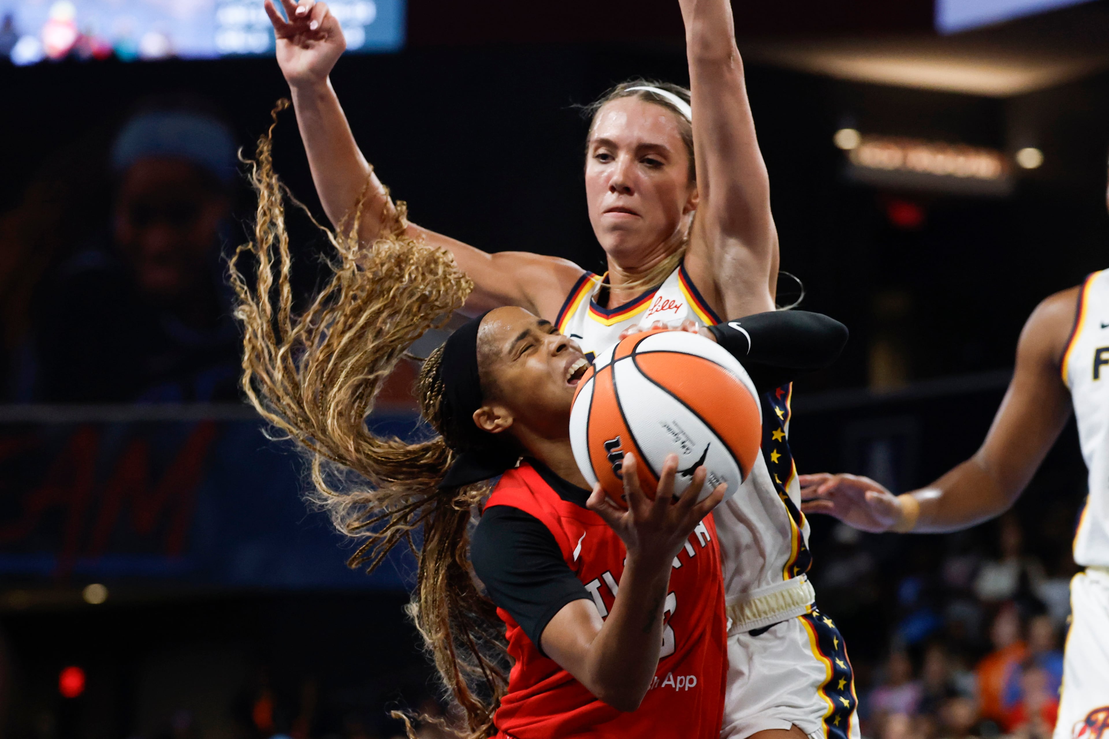 Atlanta Dream guard Jordin Canada, bottom, is fouled by Indiana Fever guard Lexie Hull, top, as she goes to the basket during the second half of Game 3 in the first round of the WNBA basketball playoffs, Thursday, Sept. 18, 2025, in Atlanta. (AP Photo/Butch Dill)