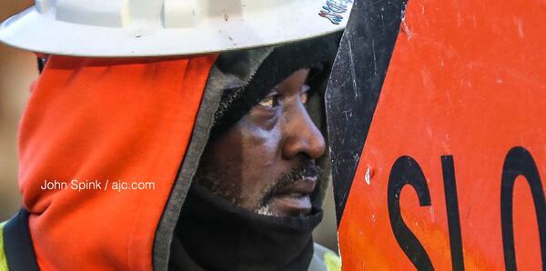 Victor Smith worked construction traffic in the 1000 block of Howell Mill Road on Thursday morning, when temperatures dipped into the 20s.