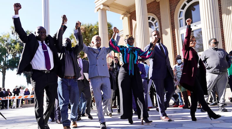 The Rev. Al Sharpton, third from the left, holds hands with Ahmaud Arbery’s parents, Wanda Cooper-Jones, right, and Marcus Arbery, left, as they react outside the Glynn County Courthouse in Brunswick, Ga., on Wednesday, Nov. 24, 2021, after the jury found three men guilty of murder and other charges for the pursuit and fatal shooting of Ahmaud Arbery. (Nicole Craine/The New York Times)