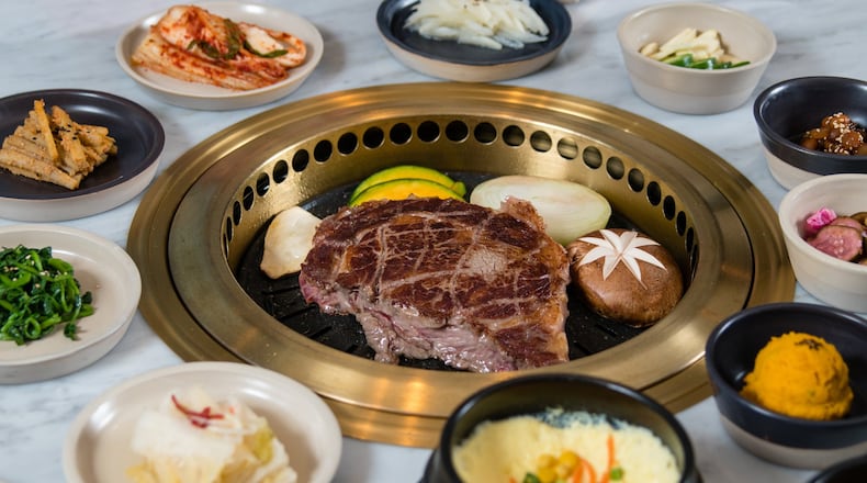 A large prime rib-eye steak cooks on the table-mounted grill at Ari Korean Steakhouse. CONTRIBUTED BY HENRI HOLLIS
