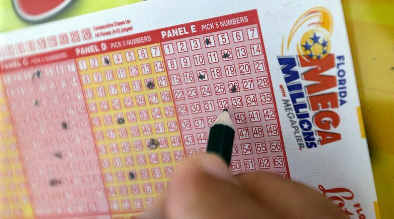 A customer fills out a Mega Millions ticket at a local grocery store, Friday, July 1, 2016, in Hialeah, Fla. Friday night's Mega Millions drawing will give lottery players a shot at the 10th largest jackpot in U.S. history. (AP Photo/Alan Diaz)
