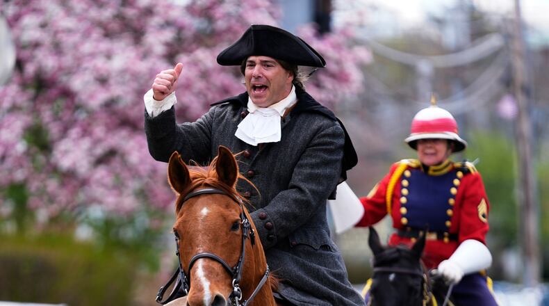 Brig. Gen. Richard Reale, dressed as American patriot Paul Revere, left, and outrider Cyndi Sumner reenact the 1775 Boston-to-Lexington ride to alert colonists of approaching British troops, Monday, April 20, 2026, in Somerville, Mass. (AP Photo/Robert F. Bukaty)