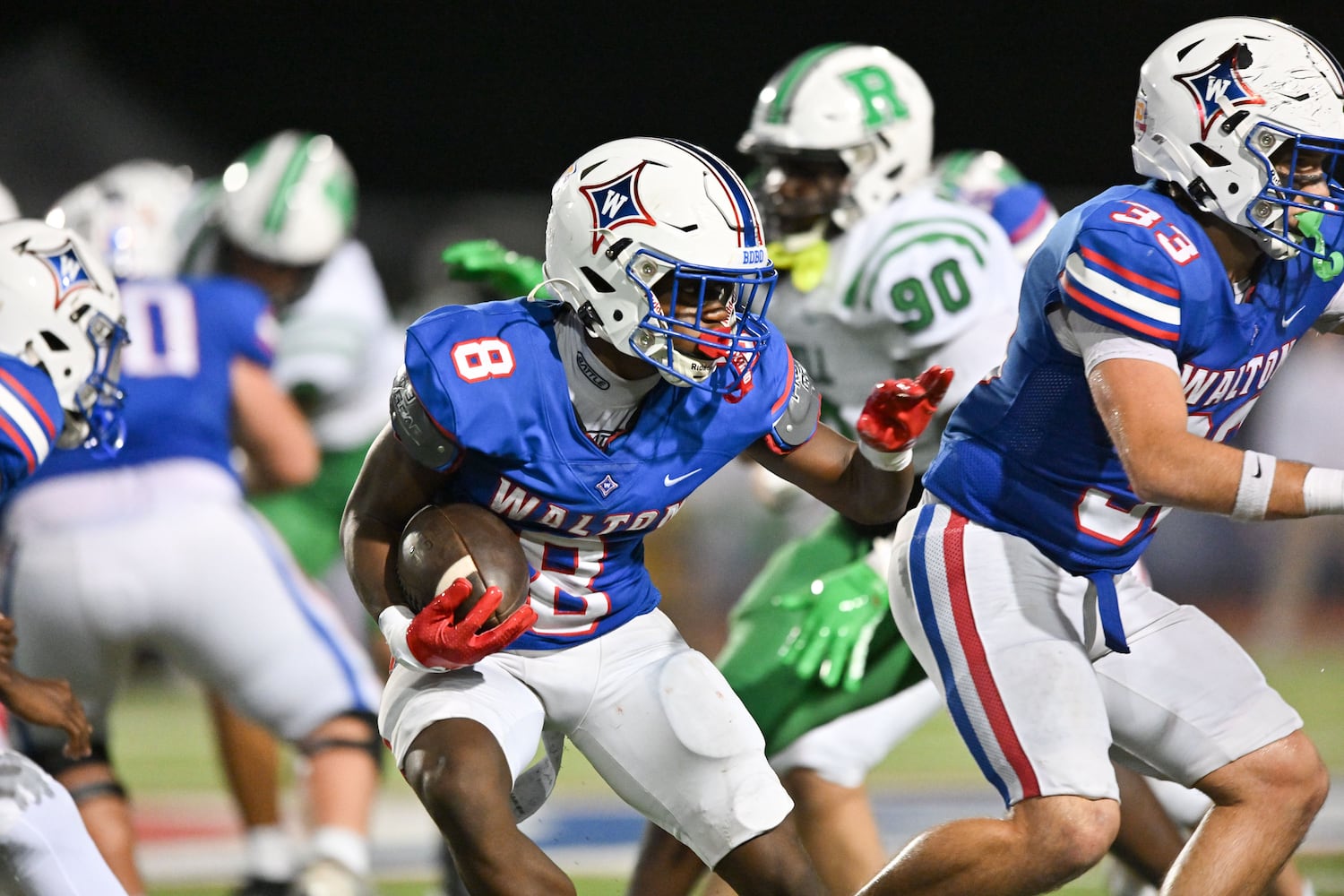 Walton running back Noriega Thompson (8) carries for a short gain in yardage against Roswell during the second half of a game Friday, August 29, 2025 at Walton High School. (Daniel Varnado/For the Atlanta Journal-Constitution)