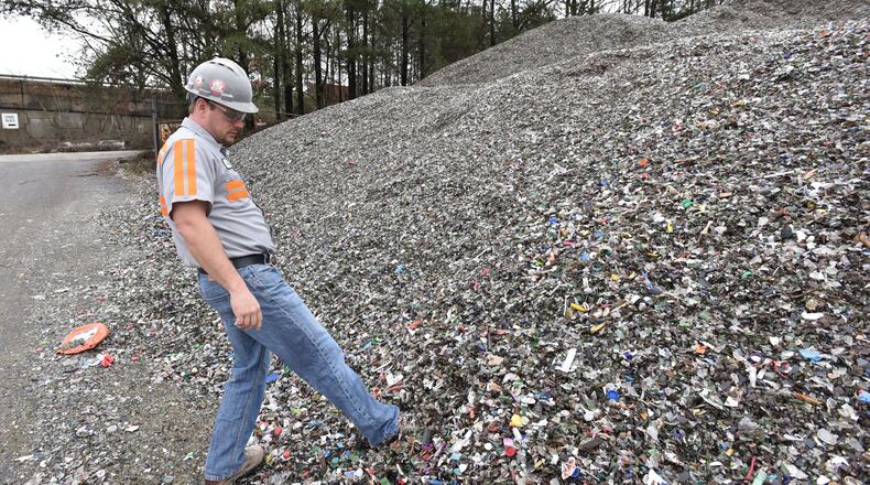 Tom Fletcher, plant manger, shows mixed recyclable materials at Strategic Materials recycling facility in College Park. (HYOSUB SHIN / HSHIN@AJC.COM)