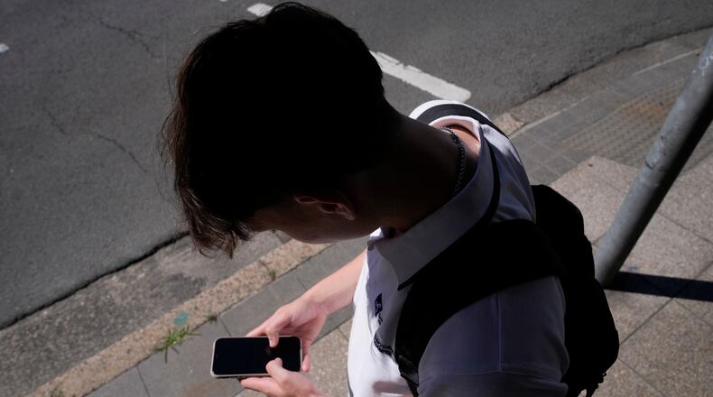 FILE - A teenage boy uses his phone in Sydney, Nov. 8, 2024. (AP Photo/Rick Rycroft, File)