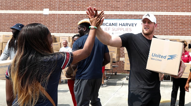 Anna Ucheomumu high-fives Texans defensive end J.J. Watt after loading a car with relief supplies for people impacted by Hurricane Harvey on Sunday in Houston. Watt's Hurricane Harvey Relief Fund has raised more than $20 million to date to help those affected by the storm.