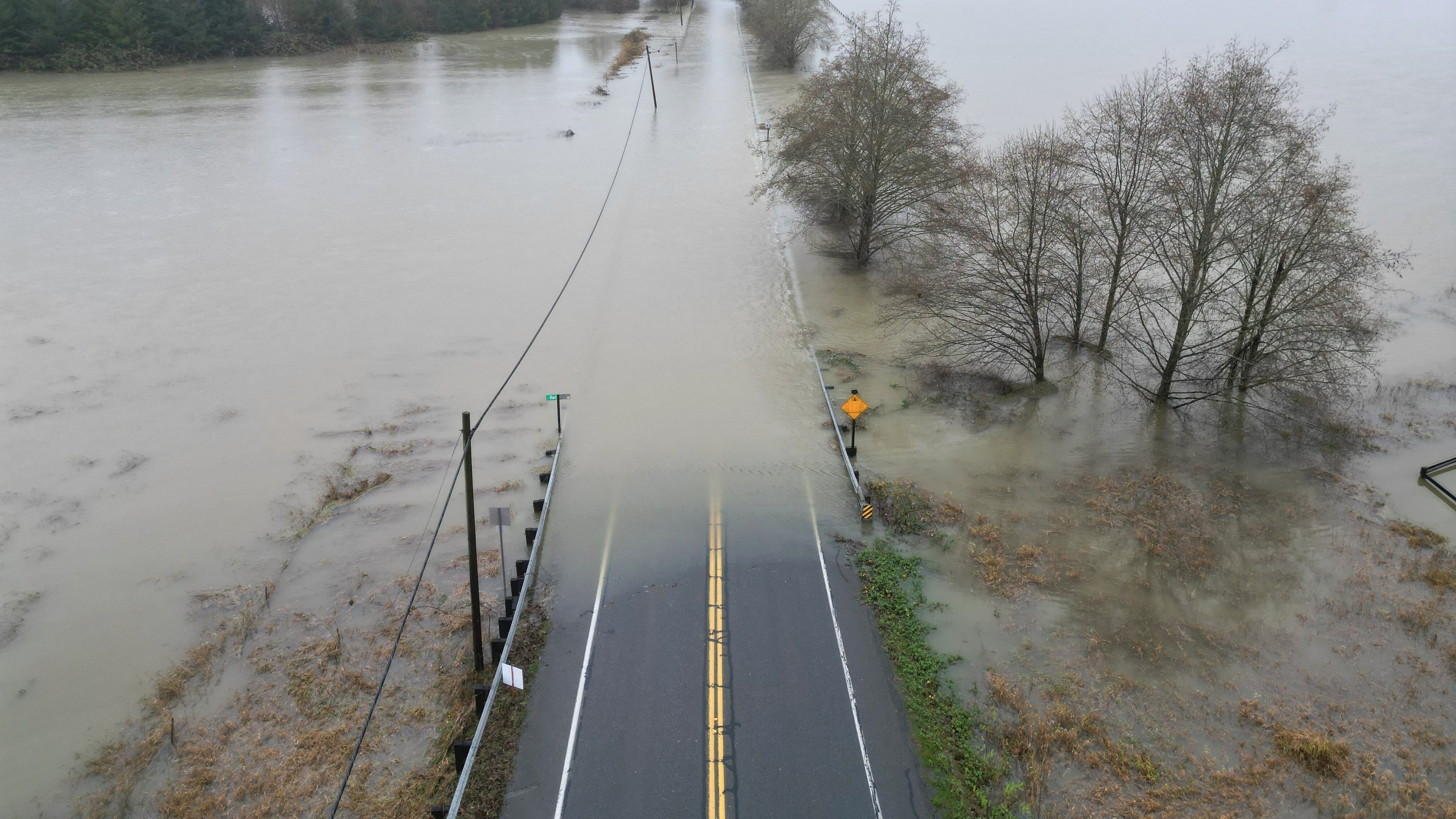 The flooding Snoqualmie River has closed NE 124th St., which connects W. Snoqualmie Valley Rd. NE on the Redmond side, and SR-203 on the Duvall and Carnation side, Wednesday, Dec. 10, 2025, near Novelty, Wash. (Ken Lambert/The Seattle Times via AP)