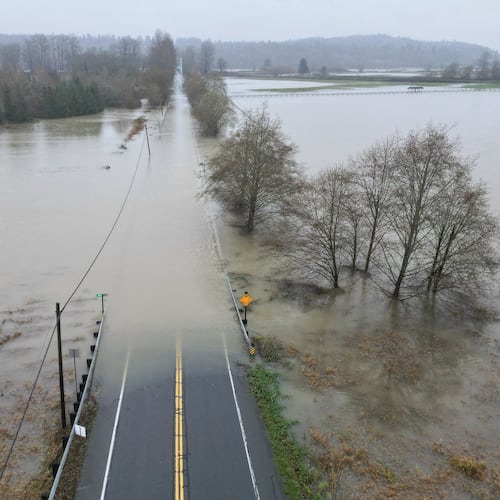 The flooding Snoqualmie River has closed NE 124th St., which connects W. Snoqualmie Valley Rd. NE on the Redmond side, and SR-203 on the Duvall and Carnation side, Wednesday, Dec. 10, 2025, near Novelty, Wash. (Ken Lambert/The Seattle Times via AP)