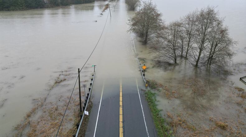 The flooding Snoqualmie River has closed NE 124th St., which connects W. Snoqualmie Valley Rd. NE on the Redmond side, and SR-203 on the Duvall and Carnation side, Wednesday, Dec. 10, 2025, near Novelty, Wash. (Ken Lambert/The Seattle Times via AP)