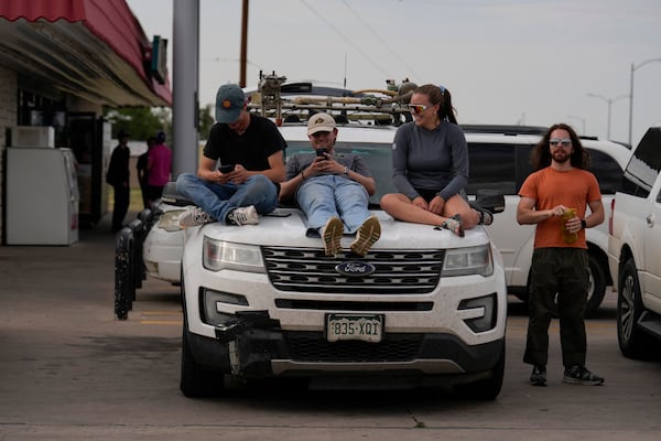 Integrated Remote & In-Situ Sensing (IRISS) lab out of the University of Colorado Boulder and Project ICECHIP members, from left, Céu Gomez-Faulk, Ryan Downey, Madison Ritsch and Andrew Mord sit atop what they call "Tracker One" in the Allsup's Convenience Store parking lot waiting for a storm, Wednesday, June 4, 2025, in Tucumcari, N.M. (AP Photo/Carolyn Kaster)