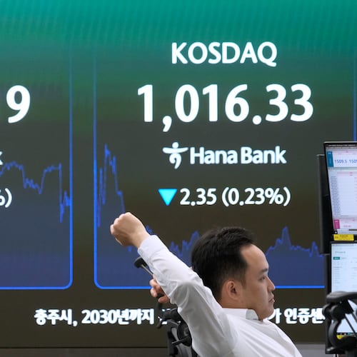 A currency trader stretches near a screen showing the Korea Composite Stock Price Index (KOSPI) at the foreign exchange dealing room of the Hana Bank headquarters in Seoul, South Korea, Wednesday, June 17, 2026. (AP Photo/Ahn Young-joon)