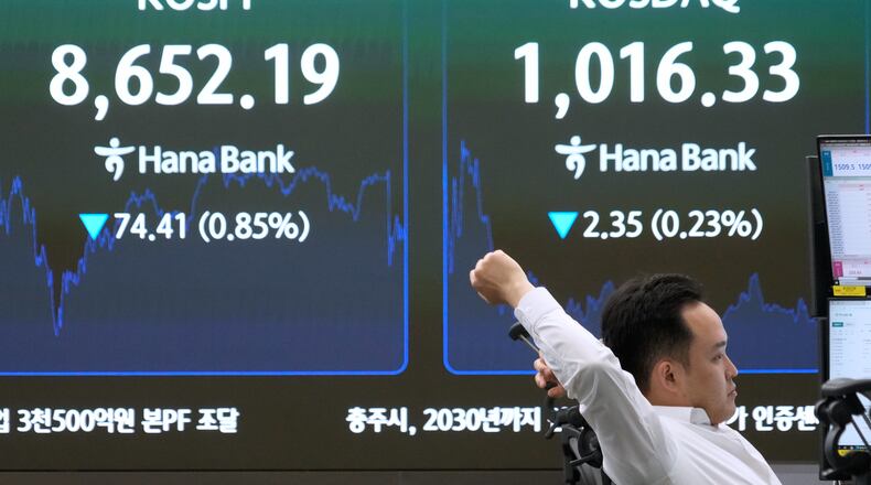 A currency trader stretches near a screen showing the Korea Composite Stock Price Index (KOSPI) at the foreign exchange dealing room of the Hana Bank headquarters in Seoul, South Korea, Wednesday, June 17, 2026. (AP Photo/Ahn Young-joon)