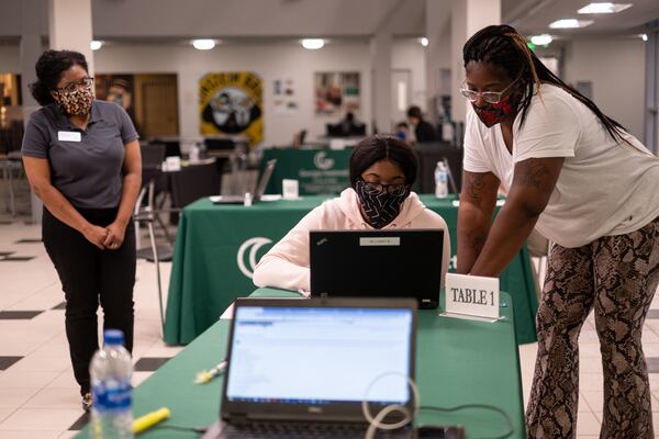 Diana Rowe (left) stays at a distance while helping Sarya Perez, accompanied by her mom Shiniqua Perez, register for classes at Georgia Gwinnett College on Monday afternoon, Aug. 3. Registration was being done by appointment, at a social distance and in an open location instead of in the normal office. BEN GRAY FOR THE ATLANTA JOURNAL-CONSTITUTION