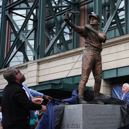Former Seattle Mariners Edgar Martinez, left, and Ken Griffey Jr., second from left, look on with right fielder Ichiro Suzuki, right, at the broken bat of Ichiro's statue during its unveiling outside of T-Mobile Park, Friday, April 10, 2026, in Seattle. (AP Photo/Lindsey Wasson)