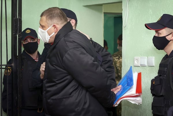 FILE - Blogger Siarhei Tsikhanouski, centre, stands outside a cage in a courtroom in remand prison in Gomel, Belarus, Tuesday, Dec. 14, 2021. (Sergei Kholodilin/BelTA via AP, File)