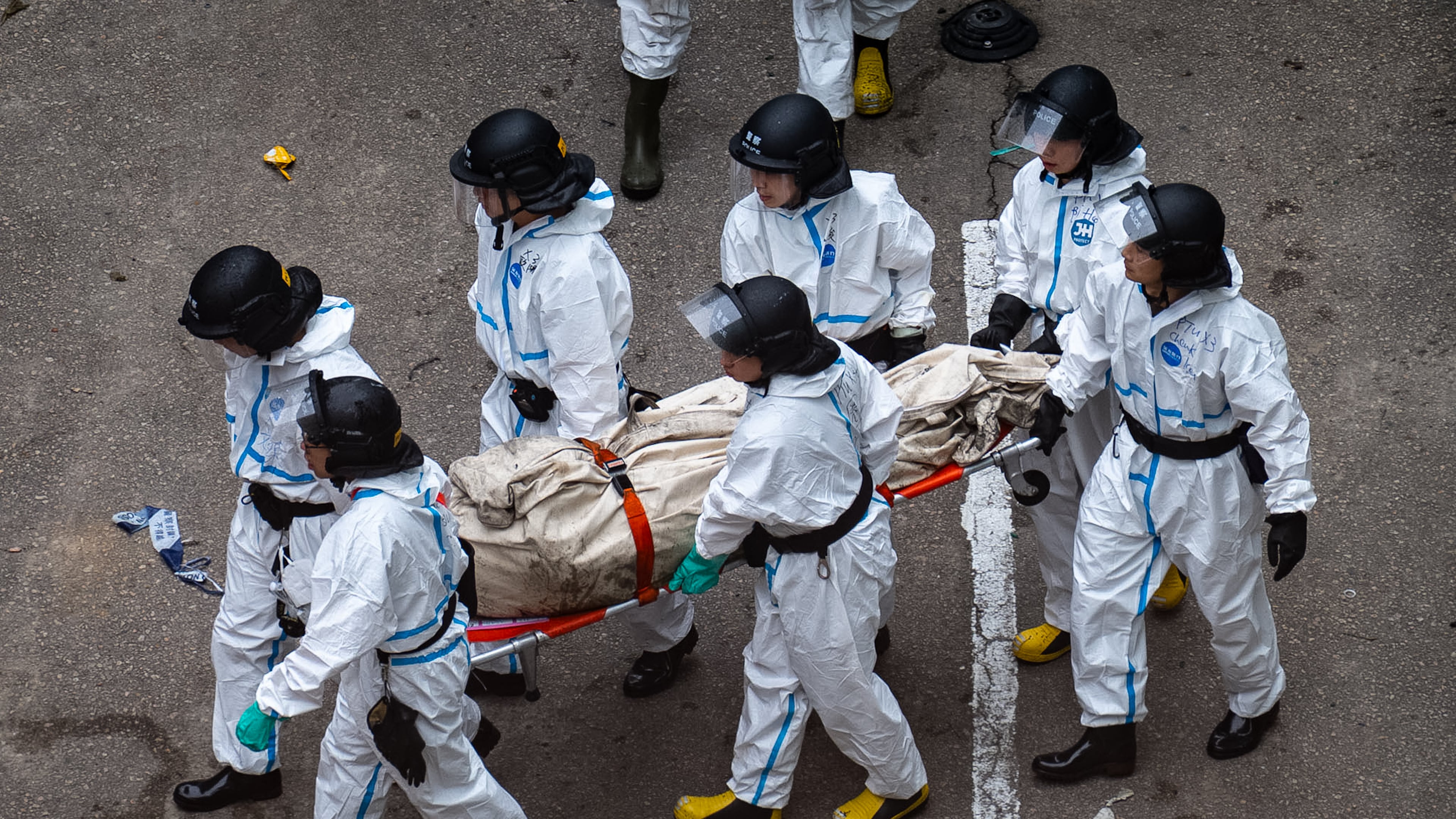 Police remove what appears to be a body bag from the site of a deadly Wednesday fire at Wang Fuk Court, a residential estate in the Tai Po district of Hong Kong's New Territories on Sunday, Nov. 30, 2025. (AP Photo/Chan Long Hei)