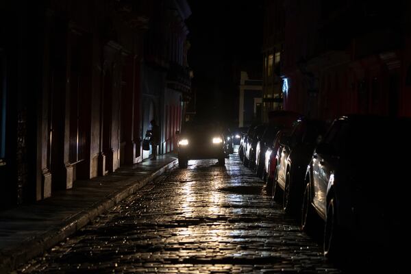 Headlights illuminate cobblestone streets in Old San Juan, Puerto Rico, during an island-wide blackout, Wednesday, April 16, 2025. (AP Photo/Alejandro Granadillo)