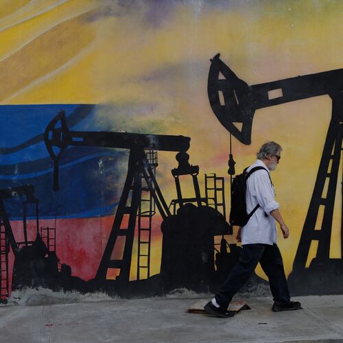 A pedestrian walks past a mural featuring oil wells in Caracas, Venezuela, Saturday, Aug 29, 2026, a day after President Donald Trump announced a deal giving the United States a stake in Venezuela’s oil reserves. (AP Photo/Pedro Mattey)