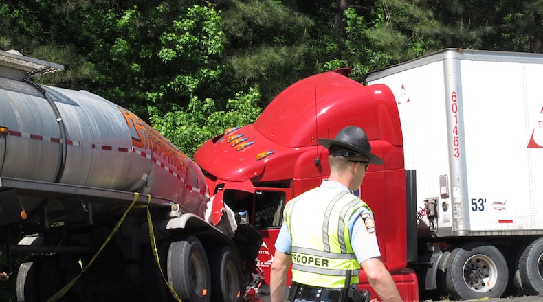 A Georgia state trooper works the scene of a deadly crash in which five people died and three others were injured early Wednesday in Ellabelle, Ga., west of Savannah. The Georgia State Patrol said seven total vehicles, including two tractor trailers, were involved in the early morning collision on Interstate 16 about 20 miles west of Savannah. (AP Photo/Russ Bynum)