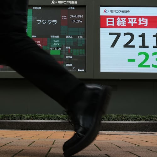 A man walks past a monitor showing Japan's Nikkei 225 index at a securities firm in Tokyo, Tuesday, June 23, 2026. (AP Photo/Hiro Komae)