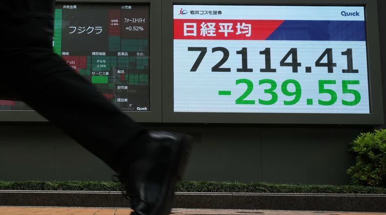 A man walks past a monitor showing Japan's Nikkei 225 index at a securities firm in Tokyo, Tuesday, June 23, 2026. (AP Photo/Hiro Komae)