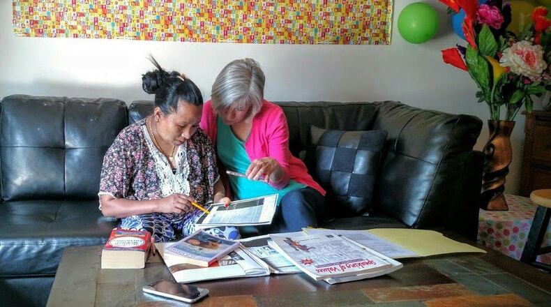 New American Pathways volunteer Carol Hamilton helps Bhim Tamangwith her homework. HANDOUT