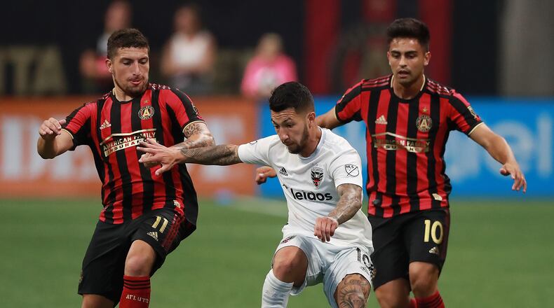 July 21, 2019 Atlanta: Atlanta United players Eric Remedi (left) and Pity Martinez double team D.C. United player Luciano Acosta in a soccer match on Sunday, July 21, 2019, in Atlanta.   Curtis Compton/ccompton@ajc.com