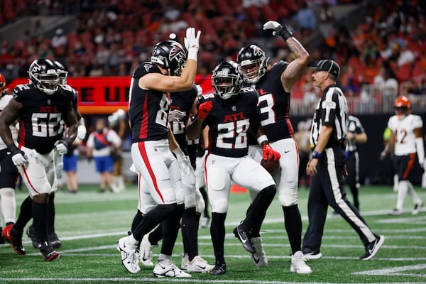 Falcons running back Carlos Washington Jr. (center) celebrates a preseason touchdown run.