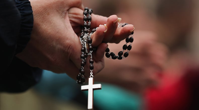 VATICAN CITY, VATICAN - MARCH 13: A woman holds rosary beads while she prays and waits for smoke to emanate from the chimney on the roof of the Sistine Chapel which will indicate whether or not the College of Cardinals have elected a new Pope on March 13, 2013 in Vatican City, Vatican. Pope Benedict XVI's successor is being chosen by the College of Cardinals in Conclave in the Sistine Chapel. The 115 cardinal-electors, meeting in strict secrecy, will need to reach a two-thirds-plus-one vote majority to elect the 266th Pontiff. (Photo by Dan Kitwood/Getty Images)