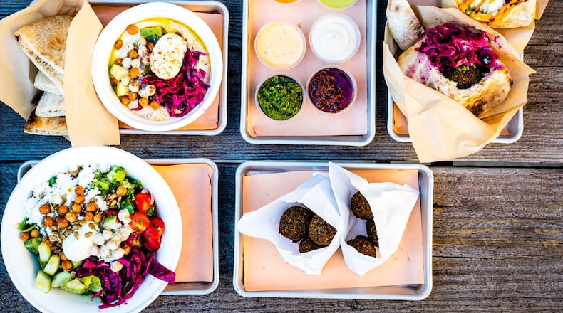 A selection of dishes from Falafel Nation, including (clockwise from top): fries with harissa aioli, accouterments, falafel pita, sabich, two falafel side orders, chopped salad and the hummus bowl. Falafel Nation is a sister restaurant to Aziza. CONTRIBUTED BY HENRI HOLLIS