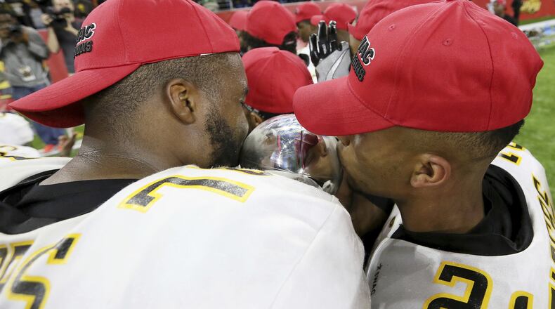 Grambling State’s Trent Scott, left, and Tyler Oliver kiss the Southwestern Athletic Conference championship trophy after defeating Alcorn State in the NCAA college football game Saturday, Dec. 3, 2016, in Houston. (Yi-Chin Lee/Houston Chronicle via AP)