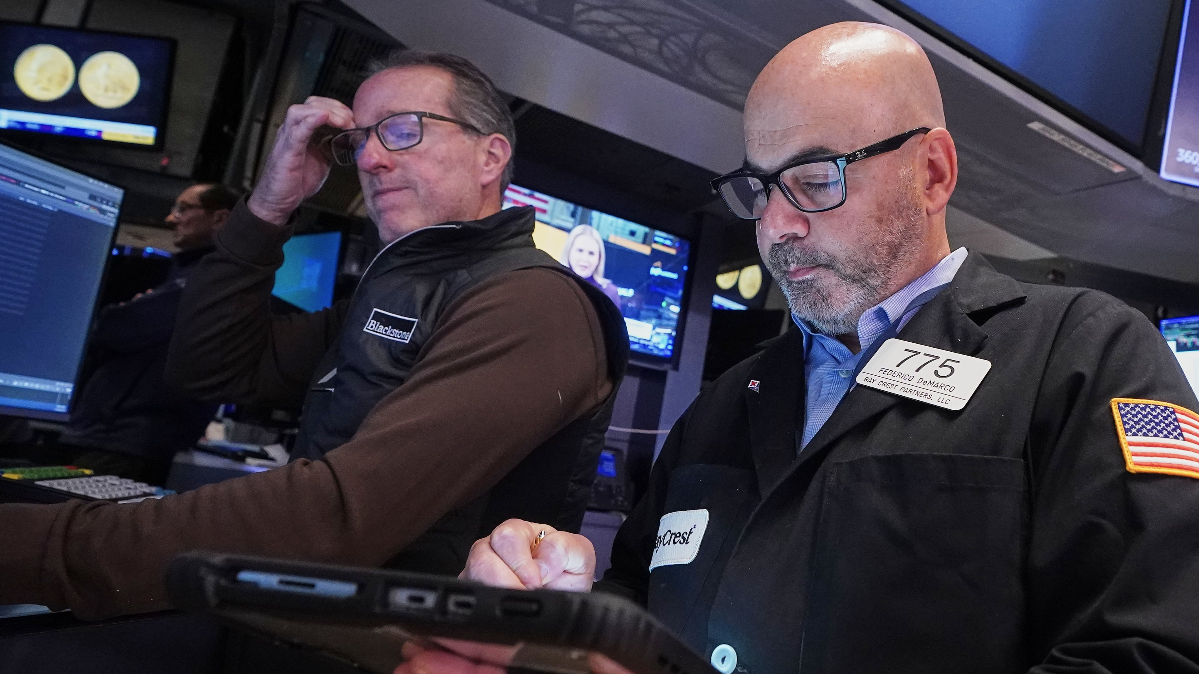 Specialist Glenn Carell, left, and trader Fred Demarco work on the floor of the New York Stock Exchange, Tuesday, Nov. 18, 2025. (AP Photo/Richard Drew)