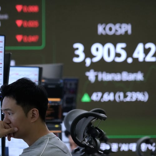 A currency trader watches monitors near a screen showing the Korea Composite Stock Price Index (KOSPI) at the foreign exchange dealing room of the Hana Bank headquarters in Seoul, South Korea, Wednesday, Nov. 26, 2025. (AP Photo/Ahn Young-joon)