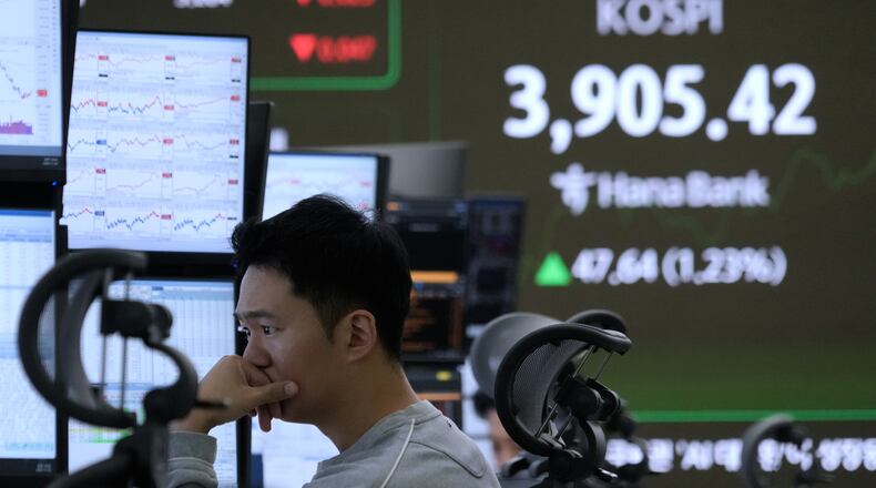 A currency trader watches monitors near a screen showing the Korea Composite Stock Price Index (KOSPI) at the foreign exchange dealing room of the Hana Bank headquarters in Seoul, South Korea, Wednesday, Nov. 26, 2025. (AP Photo/Ahn Young-joon)