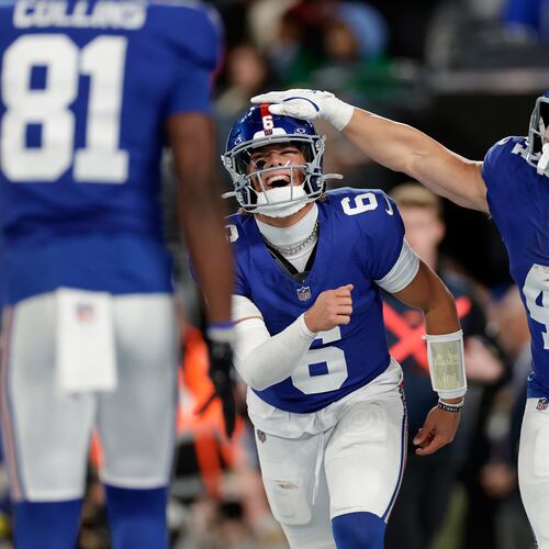 New York Giants' Jaxson Dart, center, and Cam Skattebo celebrate after a touchdown during the first half of an NFL football game against the Philadelphia Eagles Thursday, Oct. 9, 2025, in East Rutherford, N.J. (AP Photo/Adam Hunger)